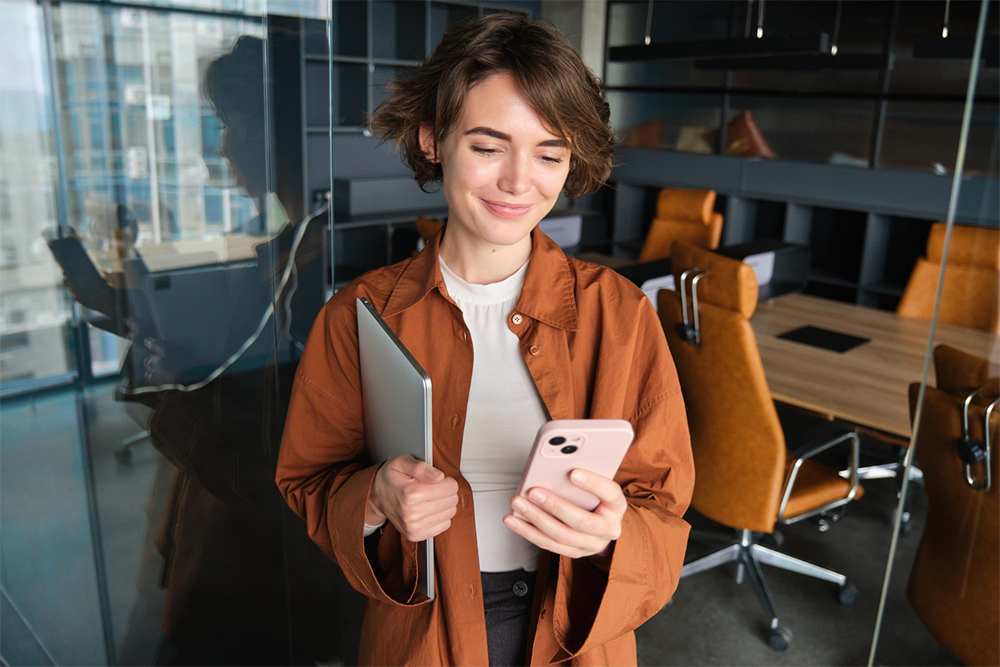 Una designer di Alessi guarda il suo smartphone da cui ha inviato un Ticket al Service Desk