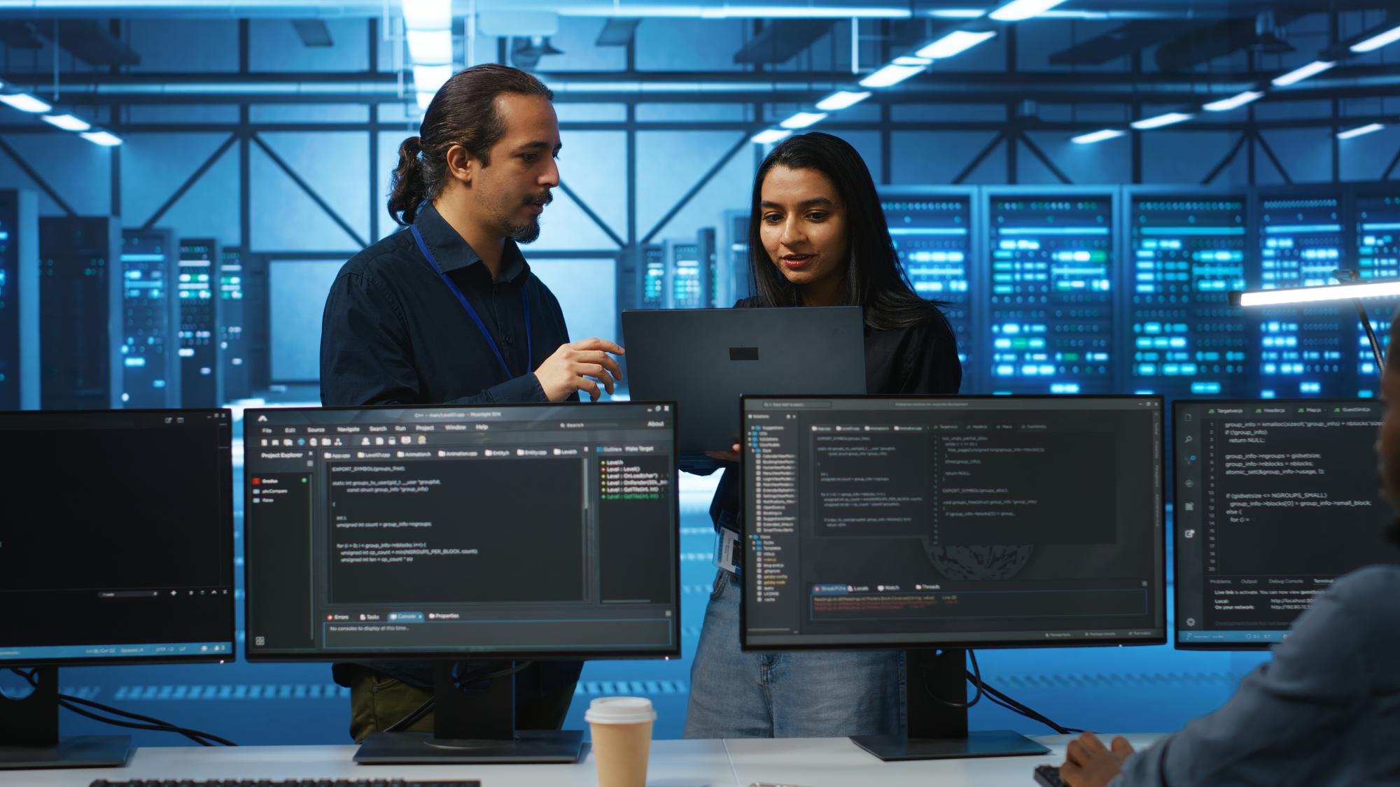 Latenza in aumento e nessun file generato sul target: la cronaca di un troubleshooting su AWS DMS. Due IT Manager che verificano la soluzione di Miriade